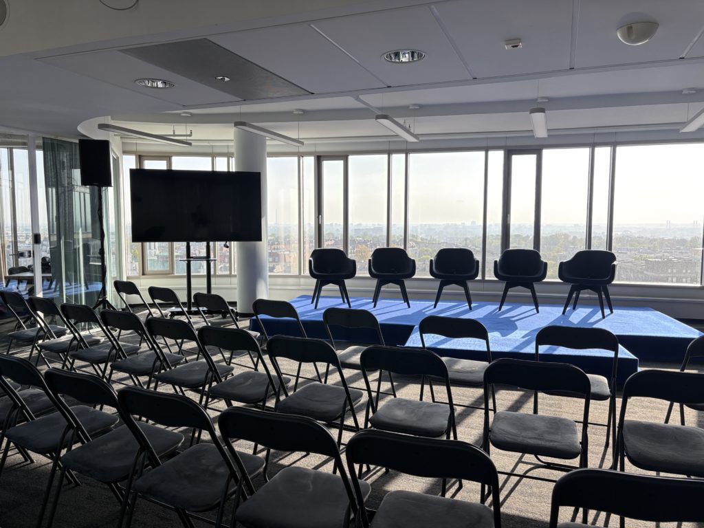 Sala konferencyjna Warszawa w układzie teatralnym na 80 osób — rzędy krzeseł, scena dla panelistów i ekran, Zebra Tower, Mokotowska 1